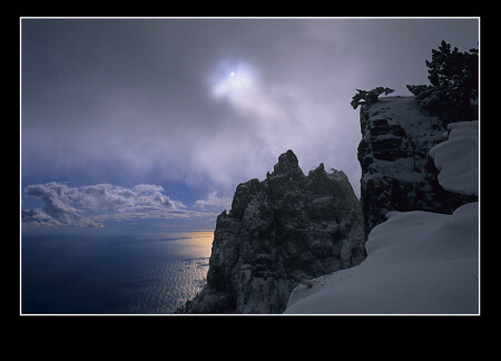 Солнца слабый свет в небесной вышине.И дремлющий залив,и черных скал вершины.