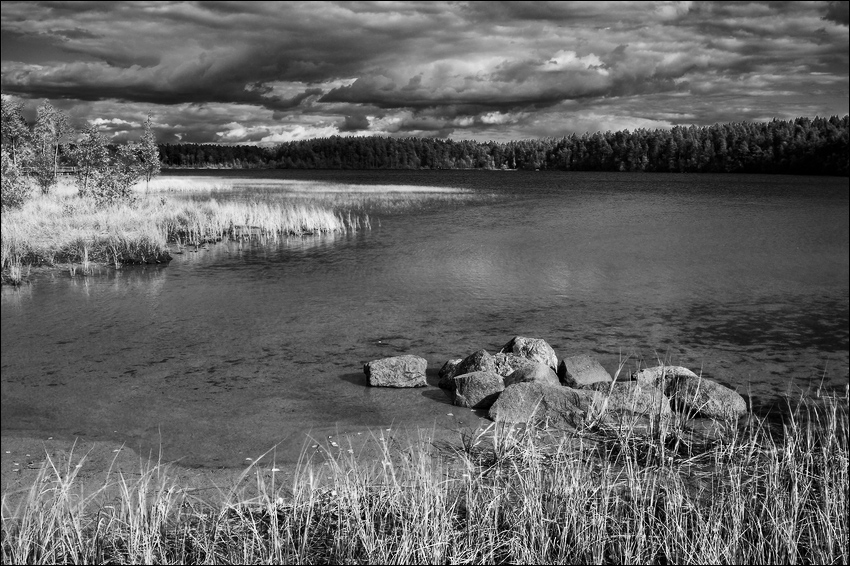 Черно-белая озерная картинка про камни в холодной воде