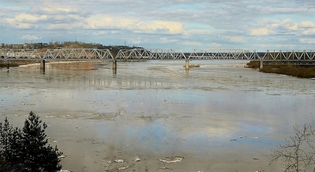 Над рекой натянуто кружево моста.