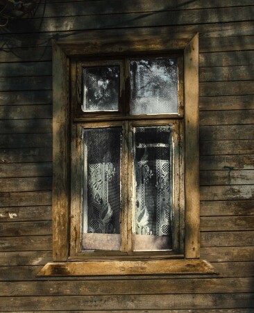 Окно с красивым тюлем в старом доме...