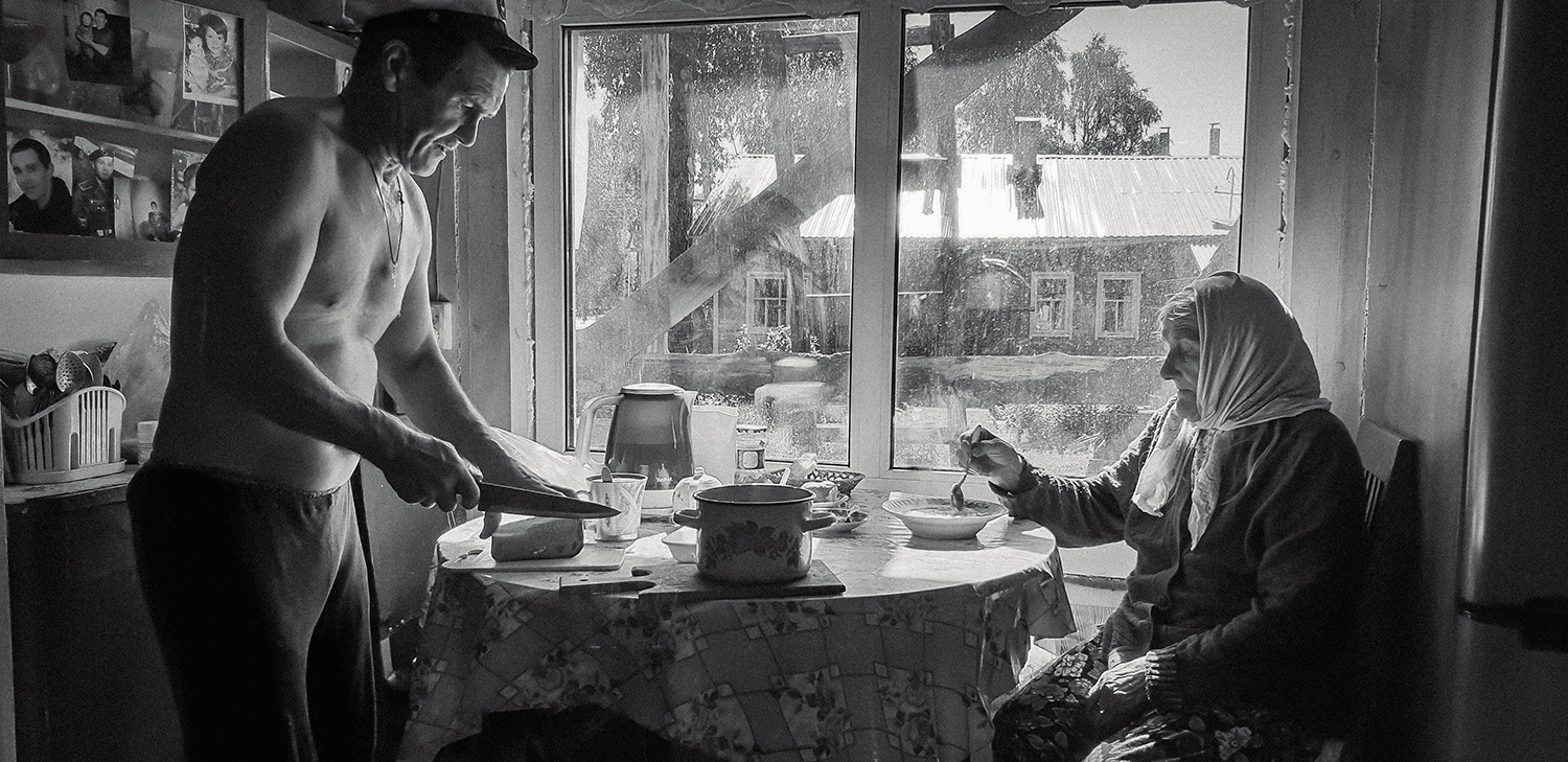 Сын кормит маму.