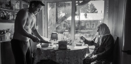 Сын кормит маму.