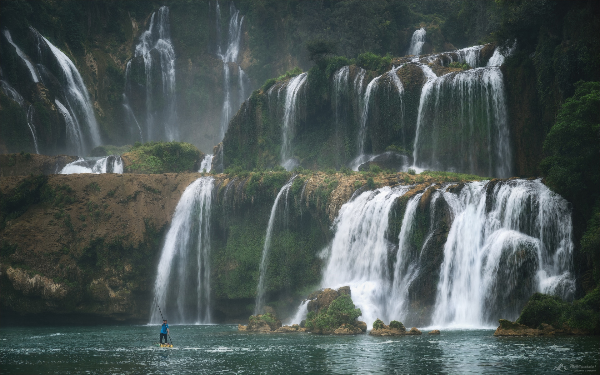 «Detian Waterfall» раздел «Природный пейзаж». «Трансграничный водопад Детиан ( Detian ) находится прямо на границе Китая и Вьетнама, где имеет вьетнамское название Банзёк ( Ban Gioc ).Это самый большой водопад в Азии и четвертый в мире, находящийся на границе двух государств.С приходом сезона дождей он резко разрастается, превращаясь в бурлящую стену воды.До водопада можно добраться с обеих сторон - вьетнамской и китайской, дрон можно запустить только со стороны Вьетнама - китайская сторона напичкана камерами слежения.Парк открывается рано, около 7 утра.И есть единственные полчаса, пока не набегут туристы и не поплывут лодки.Китай, март 2026г.(с) phototravel.pro»